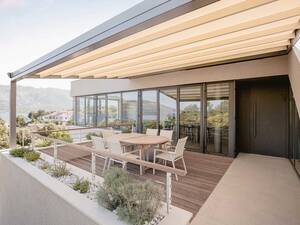 Die Pergola «Sintesi» kombiniert innovatives Design mit präziser Tuchführung und schlanken Führungsschienen. Die edle Überdachung spendet Schatten und bietet gleichzeitig Schutz vor Wind und Regen. Hella Storen AG.