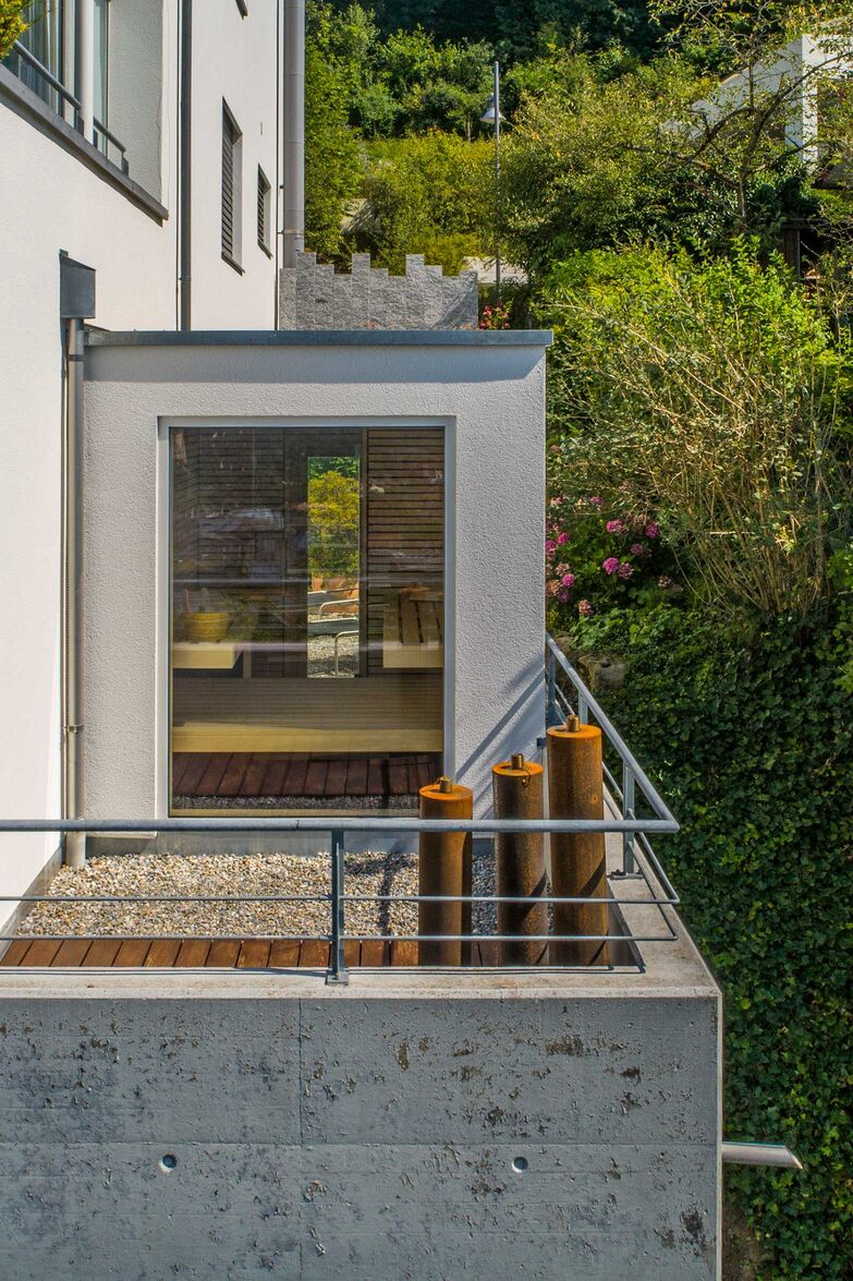 Die Aussensauna wurde genau zwischen dem bestehenden Haus und der Brüstung eingepasst und der Aussenfassade angepasst. Von innen kann durch die grossen Panoramafenster die Aussicht auf die Stadt bewundert werden. Die Sauna bietet ein luxuriöses Erlebnis durch den Einsatz von massiven Espenleisten und einen Vorraum mit Regal und Sitzbank. Sauna World AG, www.saunaworld.ch