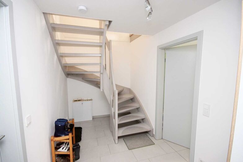 Eine offene Treppe führt in das Obergeschoss. Dank der Fussbodenheizung gibt es keinen Wärmeunterschied zwischen den Stockwerken.